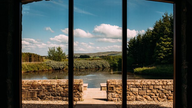 A stone bridge leading to a river with a clear sky and greenery in the background. - Laythams Holiday Lets Retreat (Clitheroe)