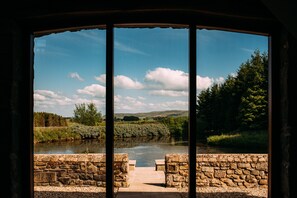 A stone bridge leading to a river with a clear sky and greenery in the background. - Laythams Holiday Lets Retreat (Clitheroe)