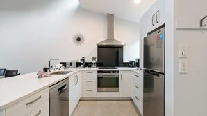 Una cucina moderna con mobili bianchi, elettrodomestici in acciaio inossidabile e forno integrato.