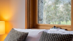 Enjoy a peaceful retreat with a comfortable bed and serene views of the surrounding trees.