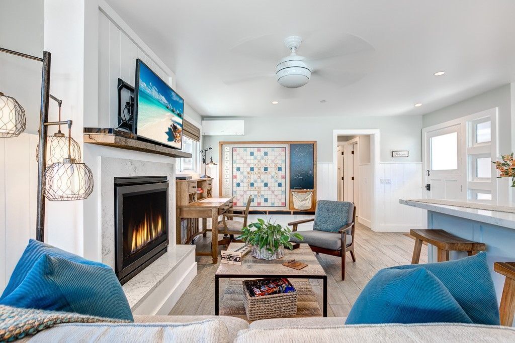A spacious living room with a fireplace, a dining area, and a kitchen.