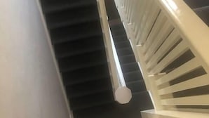 A staircase with a white handrail and black steps. - The "Crash Pad" Studio Apartment in Downtown Provo (Provo)