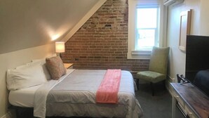 A bedroom with a bed, a chair, a desk, and a TV. - The "Crash Pad" Studio Apartment in Downtown Provo (Provo)