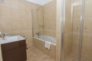 A bathroom with a bathtub, a shower, and a sink. - Noria Velha (Lagoa)