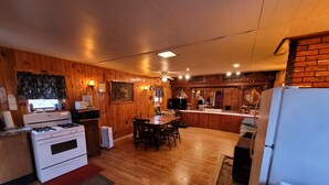 A cozy kitchen with wooden walls, a dining area, and a bar. - Blakley Hobbit Large Cabin (Viola)