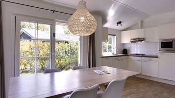 Een magnetron, een vaatwasser, een kinderstoel, eettafels