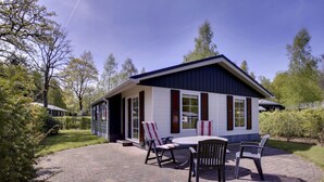 A house with a patio area featuring a table and chairs.