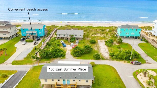 A residential area with houses and a beach in the background. There is a sign indicating '100 East Summer Place'.