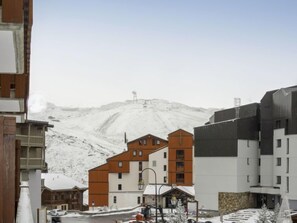 Ein schneebedeckter Berg mit Gebäuden im Vordergrund.