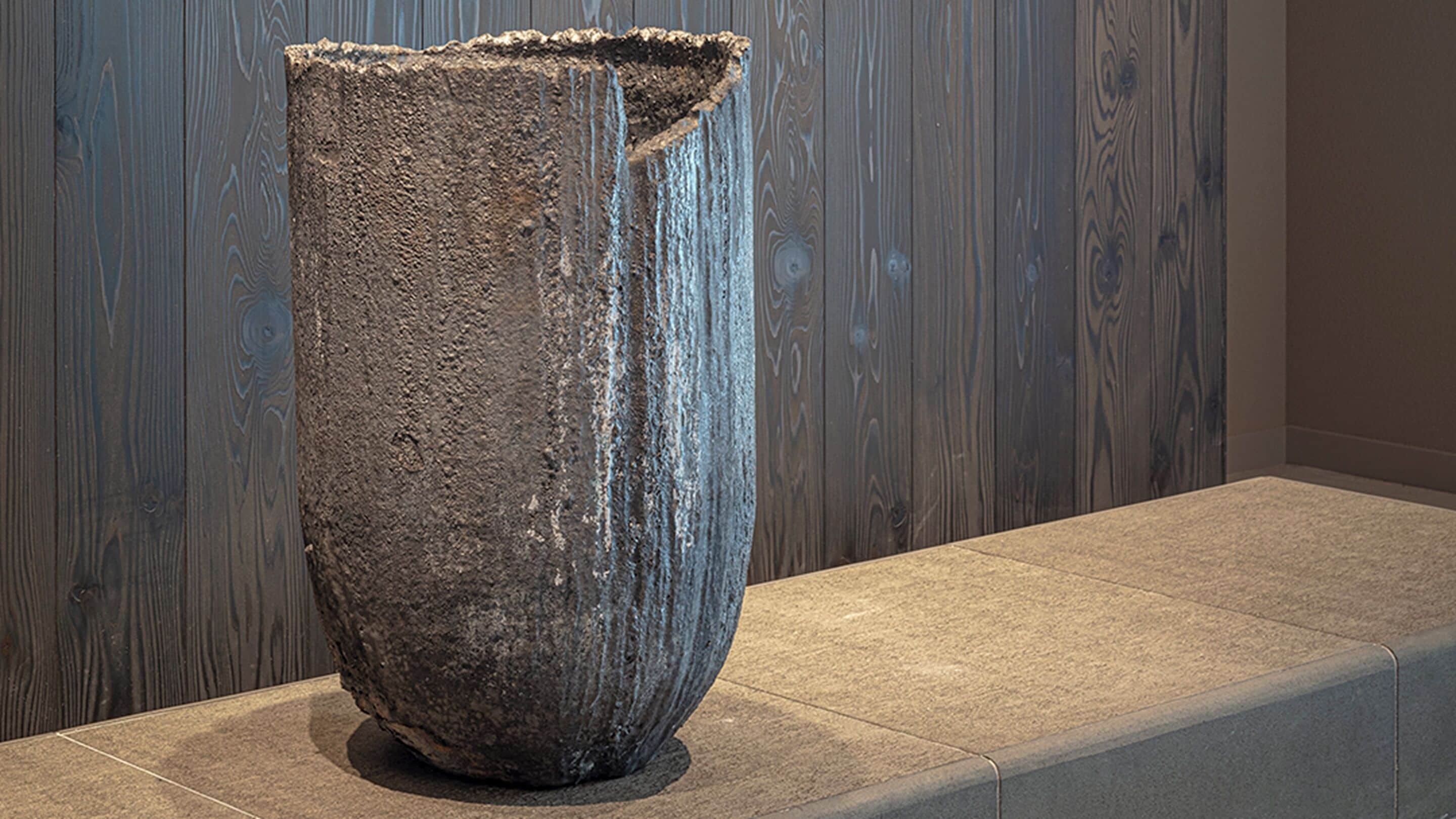 A large, textured stone sculpture in a modern setting.