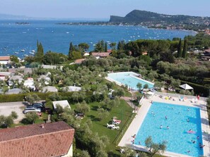 Un quartier résidentiel doté d’une grande piscine entourée de verdure et de maisons.