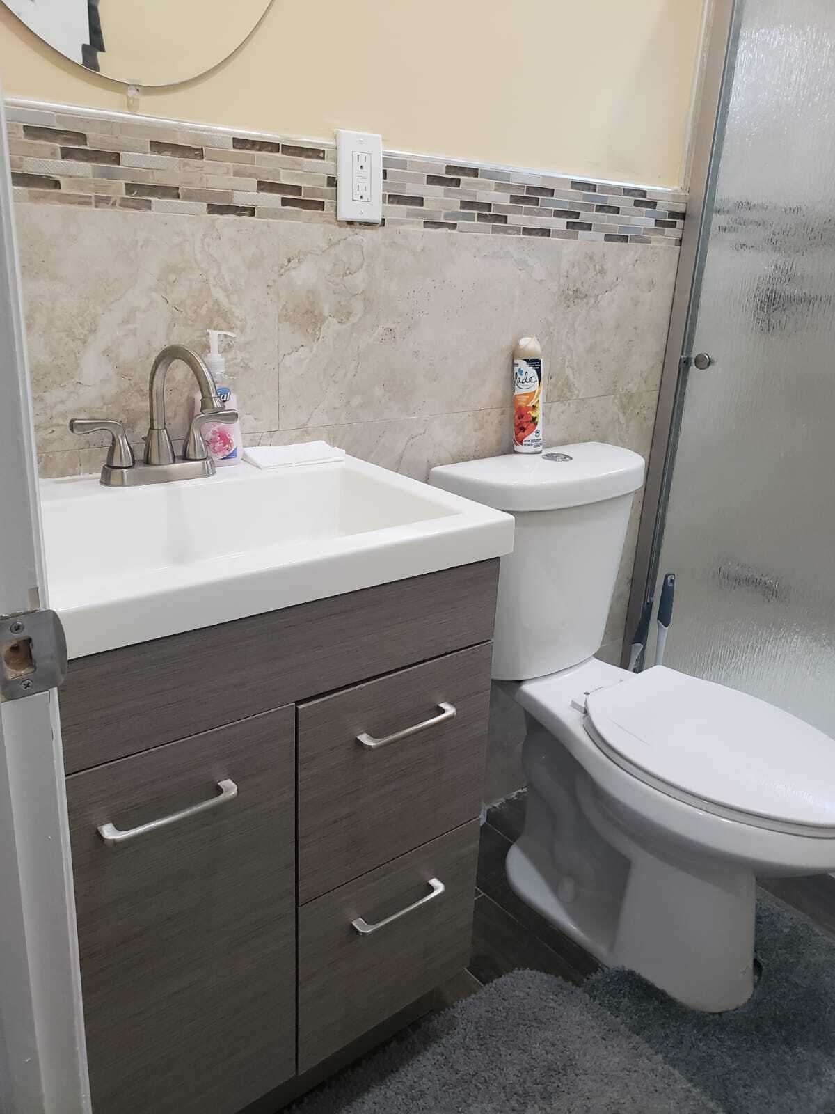 Un baño con lavamanos blanco, inodoro y zona de ducha.