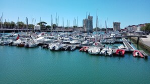 A marina with numerous boats docked, a castle-like structure in the background, and a clear blue sky. - BlanzayAprtment/1bed/Pool/Bbq/Wifi/FreeP (Blanzay)