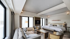 A modern hotel room with a large bed, a sofa, a chair, and a television. - The Royal Park Canvas Kyoto Nijo (Kyoto)
