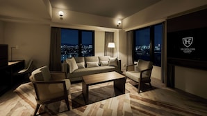 A modern hotel room with a sofa, chairs, a coffee table, and a city view. - The Royal Park Canvas Kyoto Nijo (Kyoto)