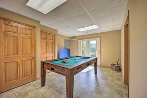 Enjoy a game of pool in this spacious room with a pool table and comfortable seating.