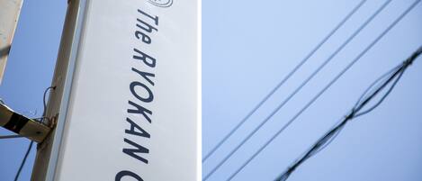 A sign with the text "The RYOKAN 9" against a clear blue sky.