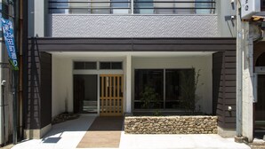 Un edificio moderno de dos pisos con fachada de piedra y una puerta de madera.