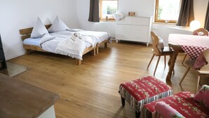 A bedroom with a wooden bed, a white dresser, a desk with a chair, and a window with curtains. - Vacation home (Eisenberg)