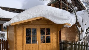 A wooden cabin with a snow-covered roof and a wooden fence surrounding it. - Vacation home (Eisenberg)