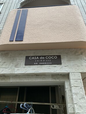 A building facade with a sign reading "CASA da COCO" and Japanese text below it.