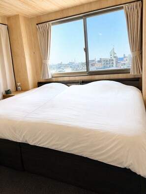 A hotel room with a large bed, wooden walls, a window with curtains, and a view of the cityscape. - A-Style Matsu 601 (Osaka)