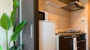 A modern kitchen with a built-in refrigerator, oven, and microwave. - A-Style Matsu 601 (Osaka)