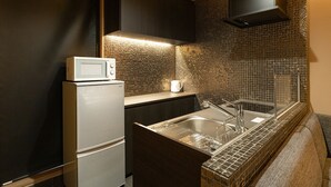 Una cocina compacta con microondas, pileta y un mueble pequeño.