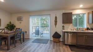 Una cocina amplia con zona de comedor, un ventanal grande y una puerta corrediza de vidrio que da a un patio.