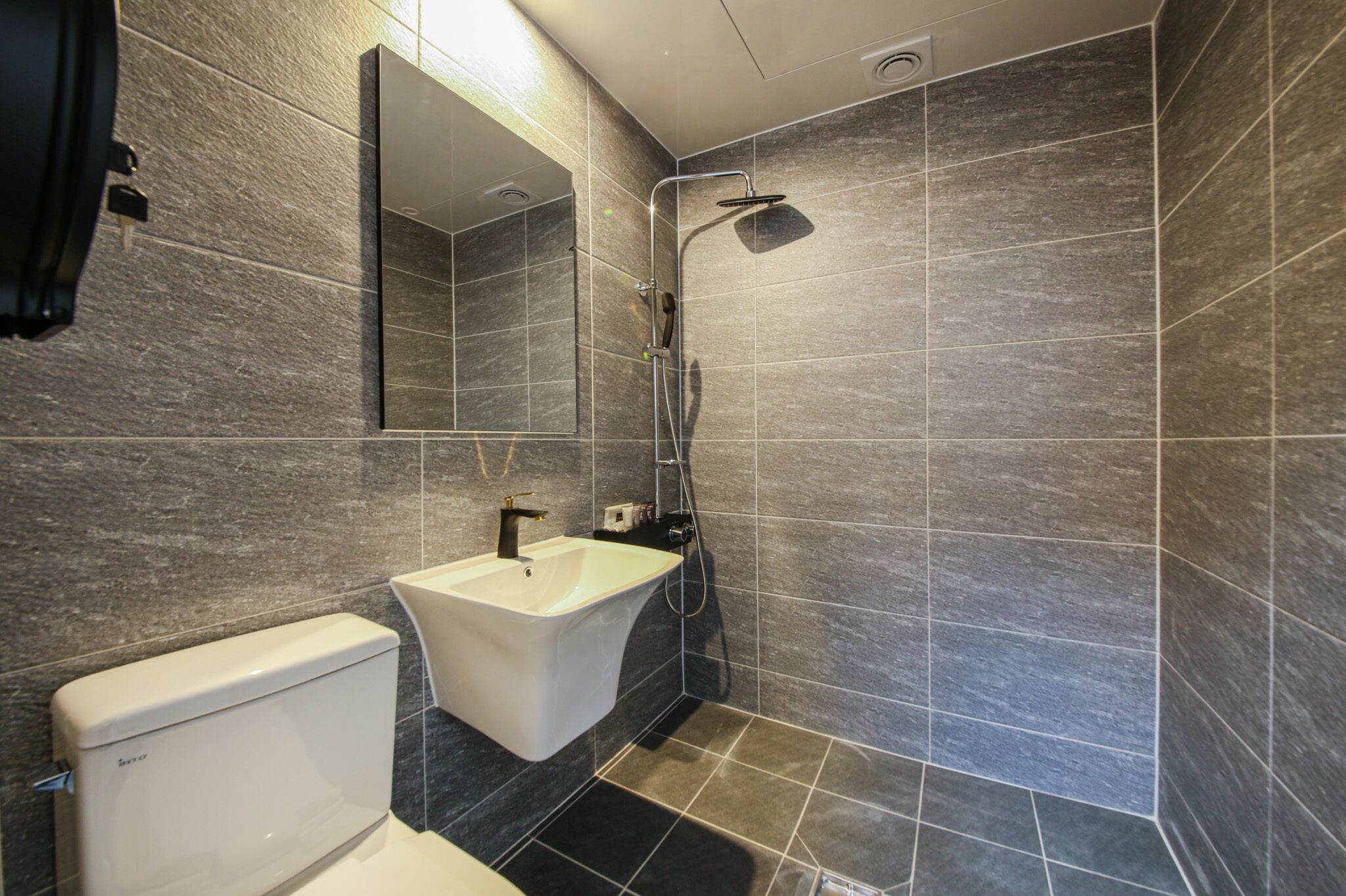 A modern bathroom with a toilet, sink, and shower.