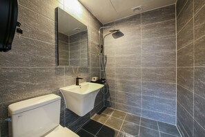 A modern bathroom with a toilet, sink, and shower. - Boutique Hotel Super Rocket (Jinju)