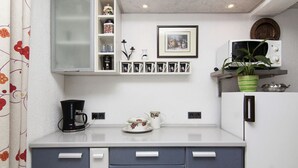 A compact kitchen with a microwave, coffee maker, and a shelf with mugs and a framed picture. - Apartment 418/952 (Istria - Valbandon), 1800m from the beach (Valbandon)