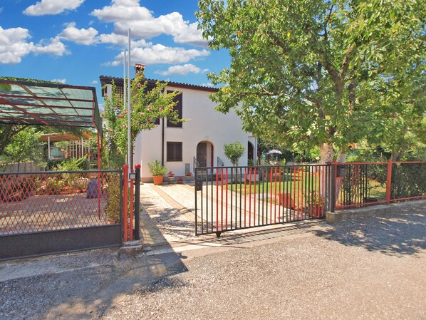 A gated property with a white building, a covered patio, and a fenced garden area. - Apartment 418/953 (Istria - Valbandon), 1800m from the beach (Valbandon)
