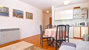 A compact living space with a dining area, kitchenette, and a radiator. - Apartment 727/1697 (Istria - Stinjan), 500m from the beach (Stinjan)