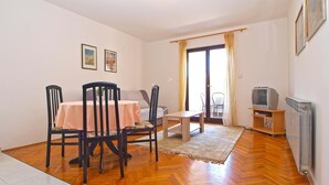 A living room with a dining table, chairs, a sofa, a TV, and a radiator. - Apartment 727/1697 (Istria - Stinjan), 500m from the beach (Stinjan)