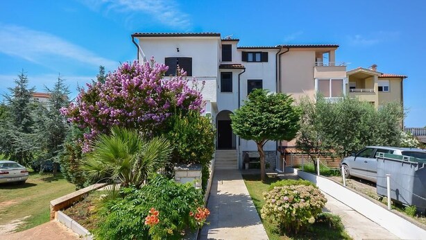 A two-story residential building with a central entrance, surrounded by well-maintained gardens and a clear sky. - Apartment 727/1697 (Istria - Stinjan), 500m from the beach (Stinjan)