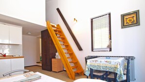 A bedroom with a bed, a desk with a chair, a window with a curtain, and a staircase. - Apartment 727/1698 (Istria - Stinjan), 500m from the beach (Stinjan)