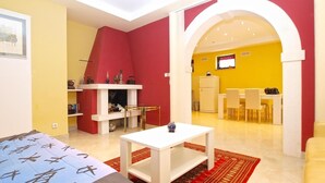 A modern living room with a fireplace, a dining area with a table and chairs, and a kitchen in the background. - Apartment 727/1700 (Istria - Stinjan), 500m from the beach (Stinjan)