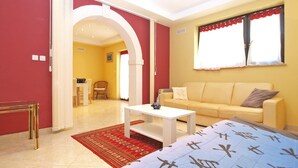 A modern living room with a sofa, a coffee table, and a red patterned rug. - Apartment 727/1700 (Istria - Stinjan), 500m from the beach (Stinjan)