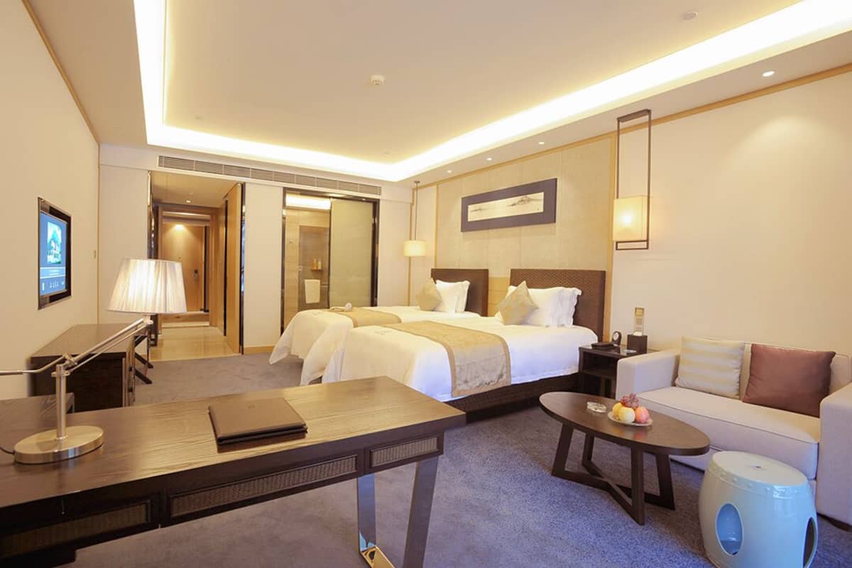 Una habitación de hotel con una cama grande, un escritorio, un sofá y una mesita.