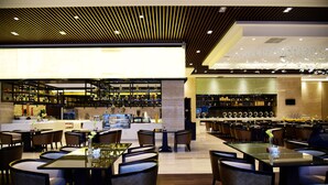 Un restaurante moderno con barra, varias mesas y sillas.