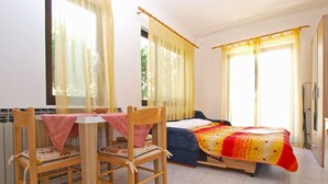 A room with a bed, a table with chairs, and a window with curtains. - Apartment 727/1701 (Istria - Stinjan), 500m from the beach (Stinjan)