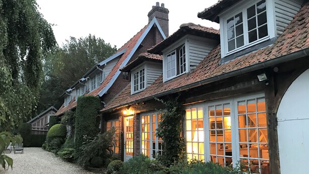 Filas de casas tradicionales con chimeneas de ladrillo, marcos de ventana blancos y un camino de grava.