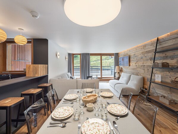 Enjoy meals in this dining area with a long table, sofa, and chairs, offering a view of the outdoors.