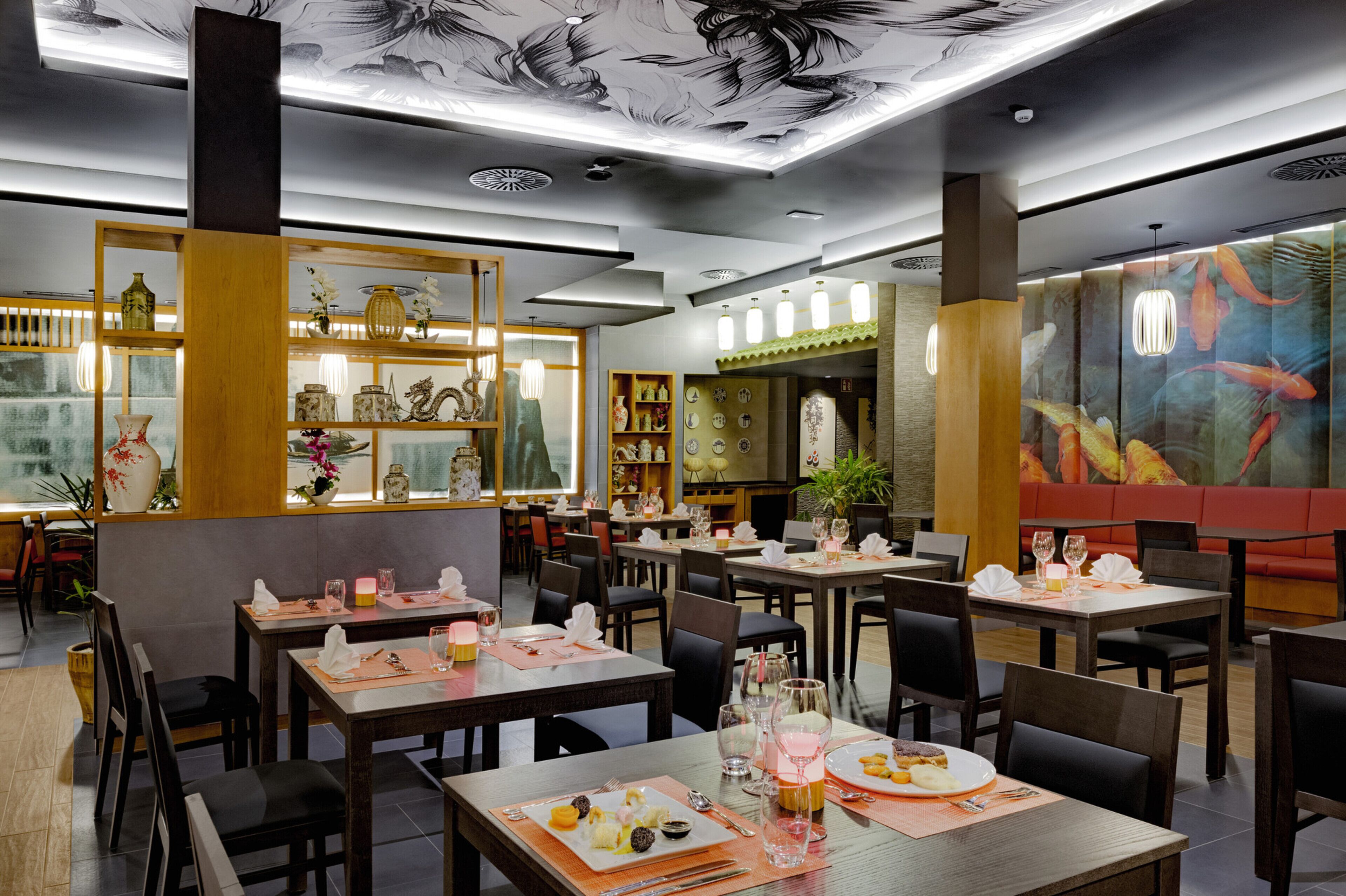 Een restaurant interieur met meerdere eettafels, stoelen en diverse decoratieve objecten op planken.