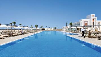 Een binnenzwembad, 5 buitenzwembaden en parasols bij het zwembad