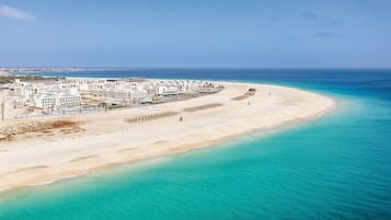 On the beach, sun-loungers, beach umbrellas, windsurfing