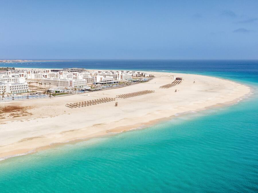 On the beach, sun-loungers, beach umbrellas, windsurfing