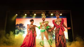 A stage with three performers in elaborate costumes.