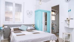 Un dormitorio con cama, armario, mesita de noche y decoración en la pared.